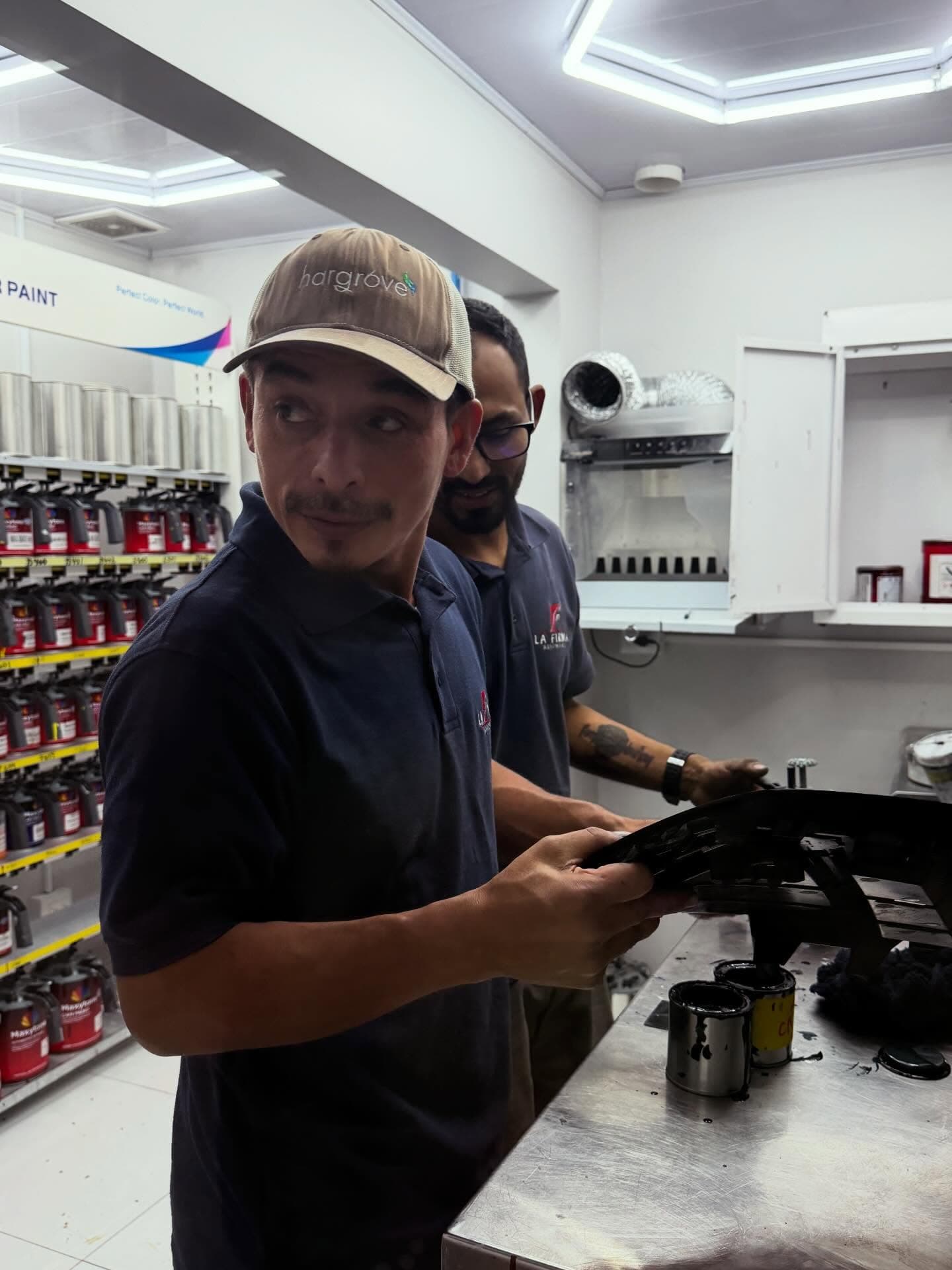 Técnico revisando una llanta y carrocería de un vehículo en el taller